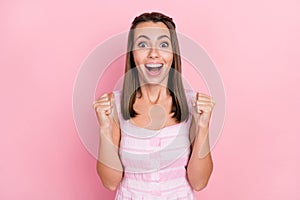 Photo of young girl amazed rejoice victory achievement fists hands win lottery isolated over pink color background