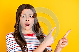 Photo of young girl amazed shocked surprised indicate fingers empty space advert decision promo  over yellow
