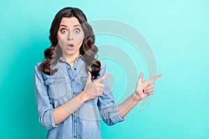 Photo of young girl amazed surprised indicate fingers empty space promo advert isolated over teal color background