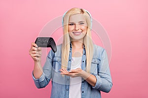 Photo of young girl demonstrate joystick select joystick advertise isolated over pink color background