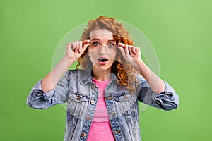 Photo of young girl hands touch eyeglasses amazed surprised look vision isolated over green color background