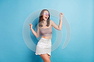 Photo of young girl happy positive smile have fun dance party sunglass isolated over blue color background