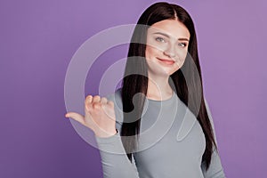 Photo of young girl point thumb empty space ad promo choose suggest isolated over violet color background