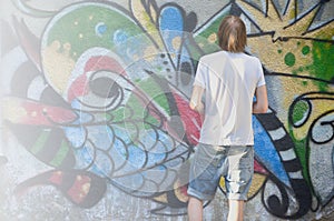 Photo of a young guy in denim shorts and a white shirt