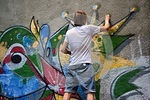 Photo of a young guy in denim shorts and a white shirt