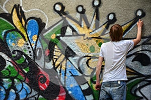 Photo of a young guy in denim shorts and a white shirt