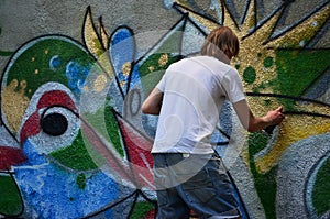 Photo of a young guy in denim shorts and a white shirt