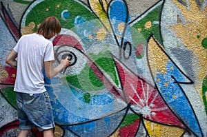 Photo of a young guy in denim shorts and a white shirt