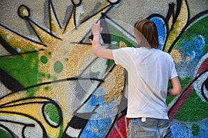 Photo of a young guy in denim shorts and a white shirt. The guy