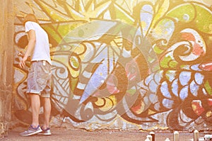 Photo of a young guy in denim shorts and a white shirt. The guy