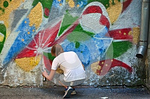 Photo of a young guy in denim shorts and a white shirt. The guy