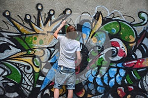 Photo of a young guy in denim shorts and a white shirt. The guy