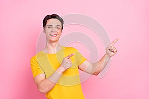 Photo of young guy happy positive smile point fingers empty space direct way ad suggest isolated over pink color