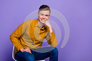 Photo of young handsome guy arm touch chin think dream confident sit chair isolated over violet color background