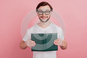 Photo of young handsome man happy positive smile read book materials isolated over pink color background