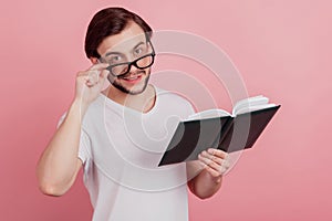 Photo of young handsome man happy positive smile read book story novel isolated over pink color background