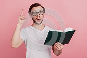 Photo of young handsome man read book story genius point finger idea isolated over pink color background