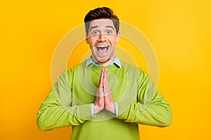 Photo of young happy excited shocked crazy smiling man asking begging for present isolated on yellow color background