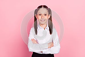 Photo of young happy small happy girl hands crossed smile good mood pupil isolated on pink color background
