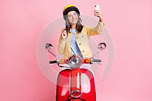 Photo of young happy smiling girl woman take selfie on phone wear yellow helmet ride red motorbike isolated on pink