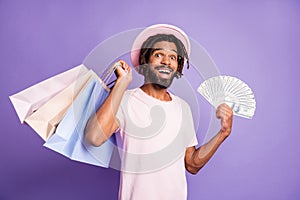 Photo of young happy smiling handsome afro man male guy hold shopping bags money dollars isolated on violet color