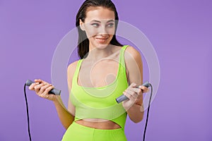 Photo of young happy woman doing exercise with jump rope and smiling
