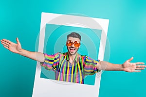 Photo of young hipster funky man wait hugs from his friends inside paper frame wear sunglasses rayban isolated on