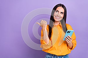 Photo of young lady blogger hold apple iphone direct finger looking empty space point finger itunes update isolated on