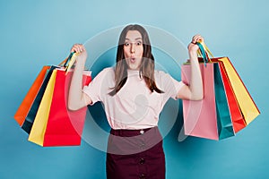 Photo of young lovely girl amazed reaction hold shopping bag big sale mall isolated over turquoise background