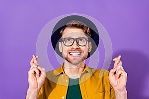 Photo of young man anxious ask beg pray crossed fingers look empty space isolated over violet color background