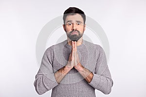 Photo of young man hands together ask beg wish pray hope expect luck  over grey color background