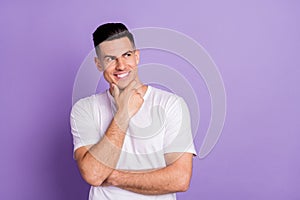 Photo of young man happy positive smile hand touch chin rhink look empty space isolated over violet color background