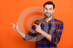 Photo of young man happy positive smile indicate fingers empty space ad select suggest recommend isolated over orange