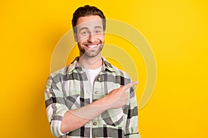 Photo of young man happy positive smile point finger empty space ad advice decision promo isolated over yellow color