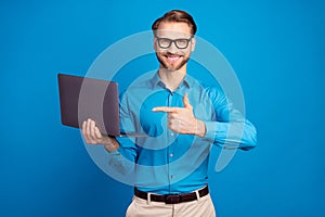 Photo of young man happy positive smile point finger laptop ads advise choice isolated over blue color background