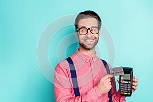 Photo of young man happy positive smile transaction payment bank card terminal nfc isolated over teal color background