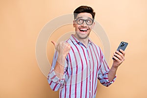 Photo of young man introducing youtube business tips information hold phone direct finger copyspace isolated on beige