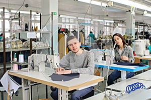 photo of a young man and other seamstresses sewing with sewing machine in a factory