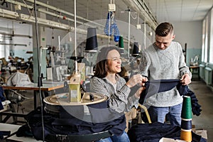 photo of a young man and a woman analysing the work at the linking machine for knitting in textile industry