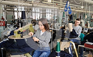 photo of a young man and a woman working with linking machine for knitting in textile industry