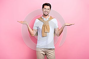 Photo of young model man wear trendy t shirt hands holding balance two arms compare products choose best isolated on
