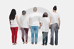 Back view of young multi-ethnic friends in casuals holding hands over white background photo