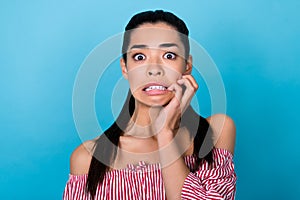Photo of young nervous girl panic biting her nails hand crazy staring scared high prices no discount isolated on blue