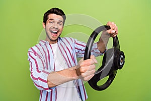 Photo of young overjoyed funny amazed guy enjoy his car holding steering wheel driver impressed reaction isolated on