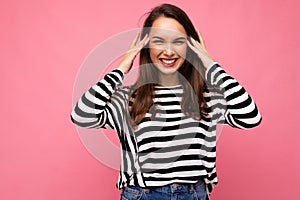 Photo of young positive happy smiling beautiful brunette woman with sincere emotions wearing casual striped pullover