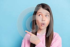 Photo of young preteen girl amazed surprised look point finger empty space ad promo suggest isolated over blue color