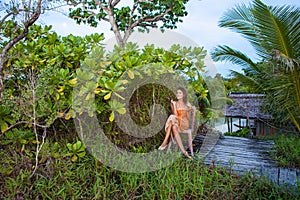 Photo Young Pretty Girl Enjoying Exotic Fruits in Jungle House Sunset. Smiling Woman Spending Chill Time Outdoor Summer