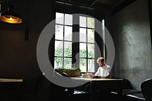 Photo of young readhead bearded man in white shirt reading a boo