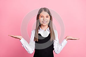 Photo of young school girl happy positive smile hold hands advert pros cons promo isolated over pink color background