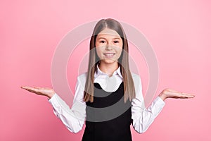 Photo of young school girl happy positive smile hold hands advert pros cons promo  over pink color background